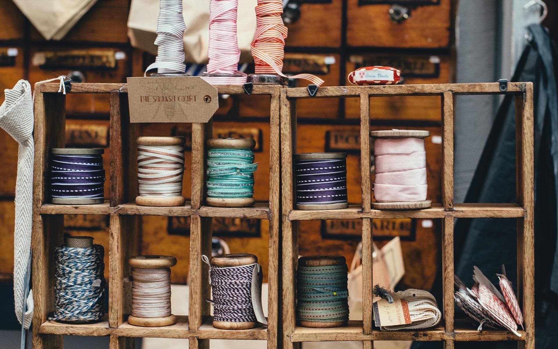 Spools of ribbon and thread on a tailor's shelf